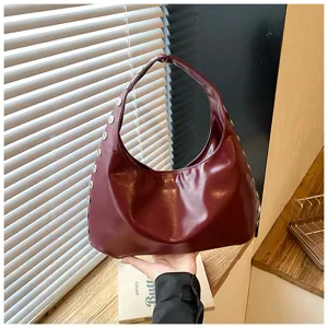 Shiny burgundy PU leather shoulder bag with punk-style silver rivets detailing.