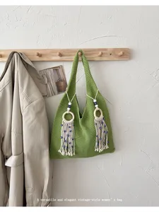 Grüne gestrickte Umhängetasche im Vintage-Stil mit Quasten an einer Holzleiste