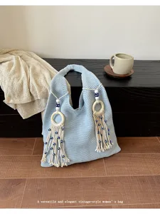 Elegante hellblaue Stricktasche mit Holzringen und Quasten mit bösem Blick Detail