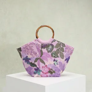 Detailansicht einer eleganten lila Stickerei-Handtasche mit Pailletten und Bambusgriffen