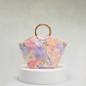 Detailansicht der 3D-Blumenstickerei und Pailletten auf der eleganten Tasche mit Bambusgriff.