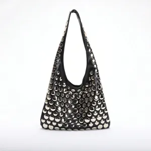 Gros plan d'un sac à main hobo punk noir orné de grands clous circulaires argentés