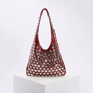 Vue détaillée d'un sac à bandoulière rouge punk avec rivets sur un socle minimaliste
