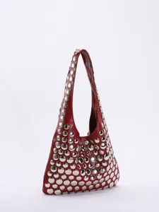 Vue détaillée d'un sac hobo rouge style punk orné de grands rivets métalliques argentés.