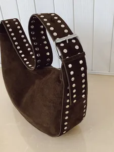 Brown suede shoulder bag with silver metal studs, slouchy hobo dumpling design for women.
