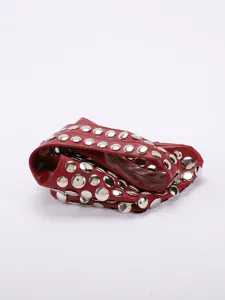 Détail d'un sac à bandoulière punk rouge tendance avec de gros rivets métalliques argentés