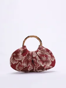 Close-up detail van de rode Chinese stijl stoffen handtas met gouden bloemenpatroon en bamboe.