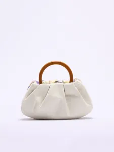 Nahaufnahme einer eleganten weißen Stoffhandtasche mit natürlichem Holzringgriff.
