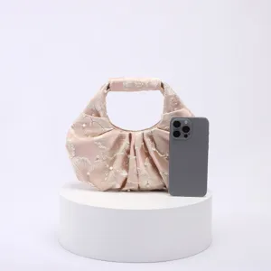 Dettaglio della borsa in jacquard con accenti di perle e pieghe fini