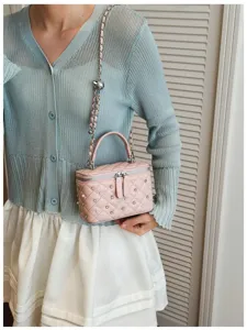 Pink quilted mini box bag with pearls and rhinestones decoration shown on a model