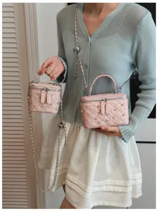 Detail of two sizes of pink quilted box bags with pearl and rhinestone accents