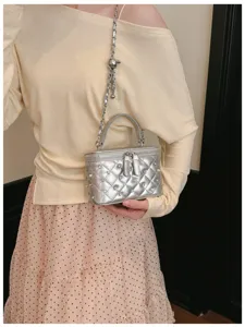 Detailed view of silver quilted vanity bag with elegant rhinestone and pearl embellishments