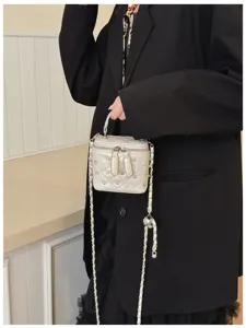 Close-up of a premium silver quilted vanity bag decorated with rhinestones and a chain strap