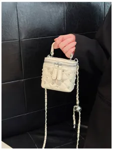 Detailed view of elegant cream quilted box bag decorated with pearls and rhinestones