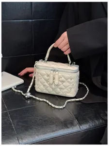 Close-up of luxury quilted diamond handbag with rhinestones and pearls detailing