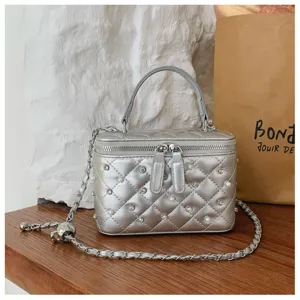 Exquisite detail of silver quilted vanity bag with pearl and rhinestone accents