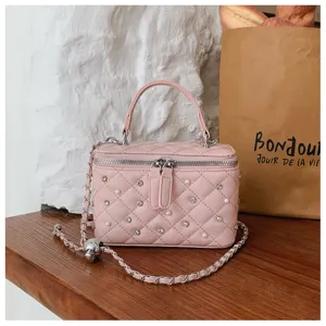 Detailed shot of a pink quilted box bag with rhinestone and pearl embellishments