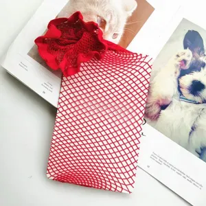 Close-up detail of red fishnet stockings featuring large mesh pattern and elegant ruffled trim