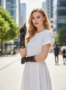Close-up of elegant black lace floral fishnet gloves worn with a white dress outdoors