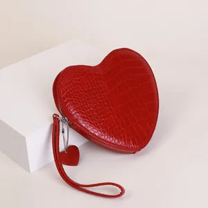 Close-up detail of red croc-textured heart coin purse with matching heart charm zipper