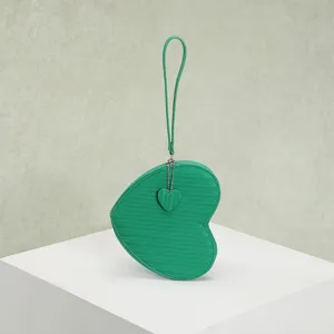 Detailed view of a green heart-shaped coin purse featuring a textured finish and pendant