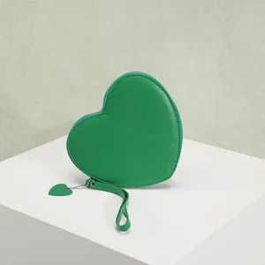 Close-up view of a stylish green heart-shaped coin purse featuring a matching heart pendant