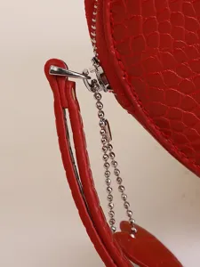 Macro view of red heart coin purse with crocodile pattern and heart zipper charm.