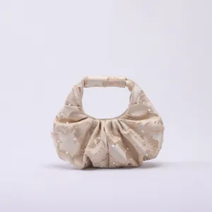 Dettaglio della borsa jacquard in stile cinese con perle e design plissettato
