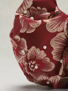Vista dettagliata della borsa a mano plissettata in jacquard cinese con eleganti perle