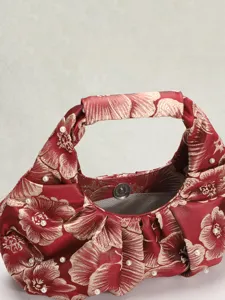 Dettaglio della borsa jacquard rossa in stile cinese con perle e chiusura magnetica.
