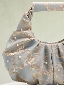 Dettaglio di borsa in jacquard stile cinese con eleganti motivi floreali e perle
