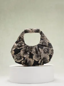 Dettaglio macro di borsa a mano plissettata in jacquard floreale vintage nero e oro
