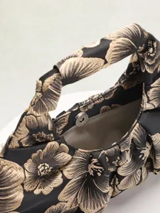 Primo piano dettagliato della trama floreale jacquard vintage e della chiusura magnetica