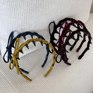 Detailed view of four colorful velvet headbands with bows and hair-gripping teeth.