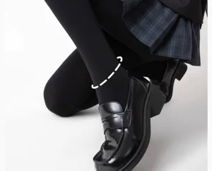 Détail de leggings thermiques noirs mats avec des mocassins et une jupe écossaise.