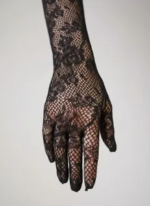 Detailed macro view of black lace glove with elegant rose pattern and fine fishnet mesh