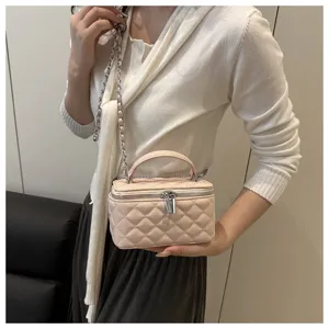 Elegante borsa a scatola trapuntata beige con tracolla a catena argento su modella