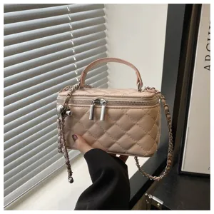 Vista dettagliata di una borsa trapuntata rosa chiaro con manico e catena argento.