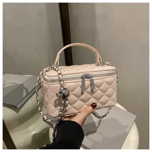 Dettaglio di una borsa a scatola trapuntata rosa con tracolla a catena