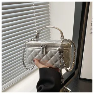 Dettaglio della borsa vanity trapuntata argento con elegante catena e manico in argento.