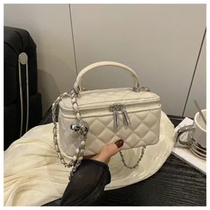 Dettaglio ravvicinato della borsa vanity in pelle trapuntata bianca con catena