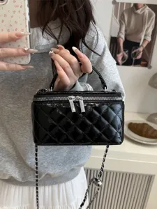 Borsa a scatola in pelle trapuntata nera con tracolla a catena argento, mostrata da modella.