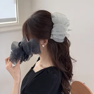 Detail of oversized polka dot seersucker hair claw clip creating a voluminous look on hair