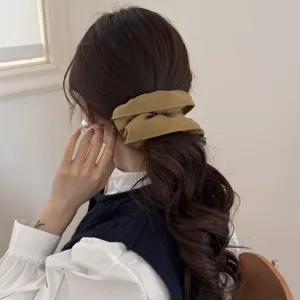 Elegante coletero scrunchie extra grande caqui en una coleta baja para un look sofisticado