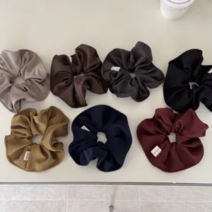 Juego de siete coleteros de tela de colores sólidos con etiquetas Hand Made en mesa