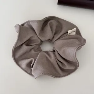 Primer plano de un coletero gris de tela acanalada con etiqueta Hand Made
