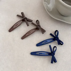 Detailed close-up of handmade bow knot hair clips in brown and navy blue denim style.