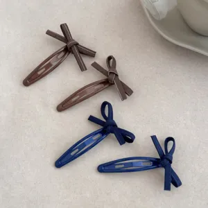 Close-up detail of sweet Korean style bow hair clips in brown and navy blue denim ribbon