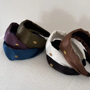 Collection of wide padded satin hairbands in diverse colors with gold logo detail