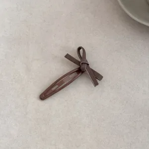 Close-up detail of a sweet Korean style brown bowknot BB hair clip for women's styling